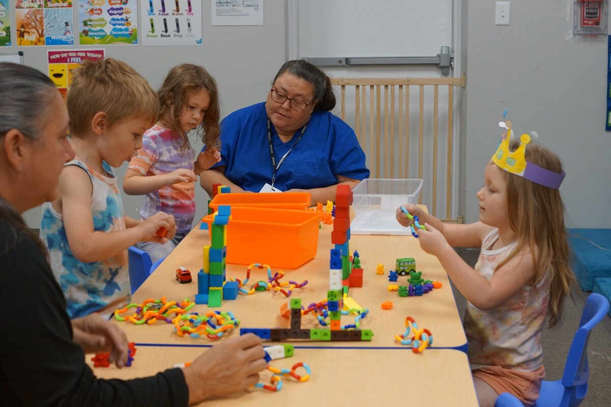 Staff with young kids building blocks and playing with toys