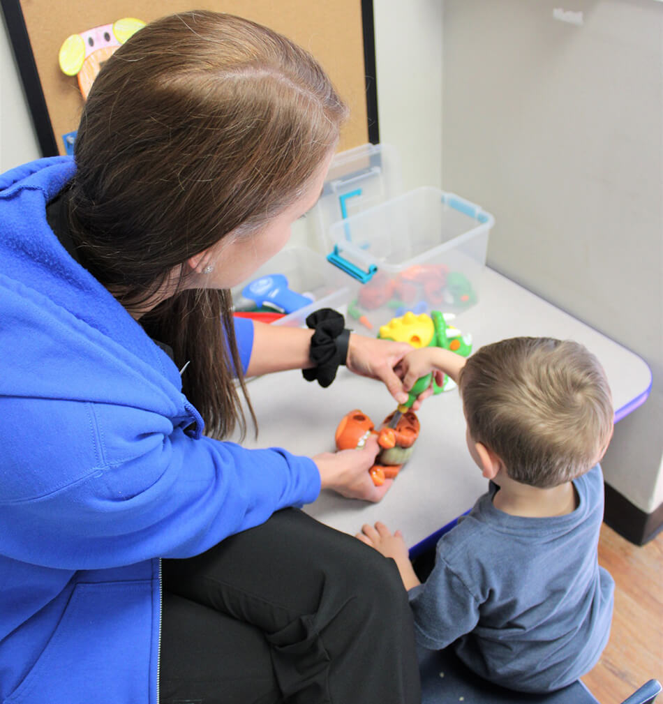 Child playing with toys while staff watches
